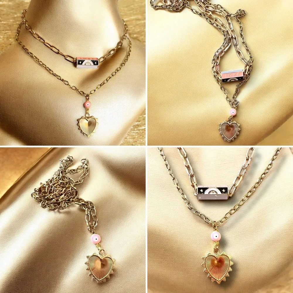 Gold toned chains with black, white, gold, and pastel pink enamel charms.